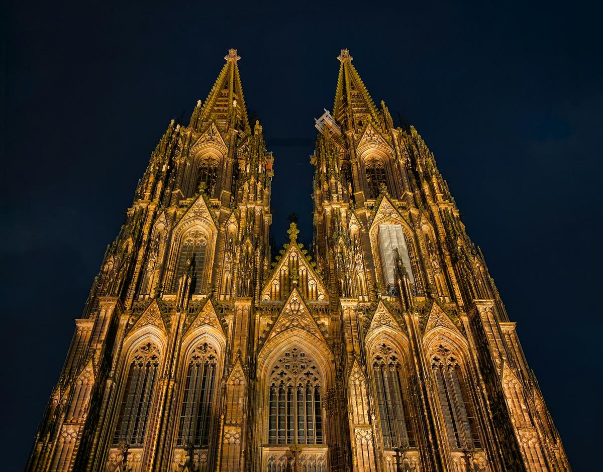 Der Kölner Dom bei Nacht, angestrahlt vor dunkelblauem Himmel
