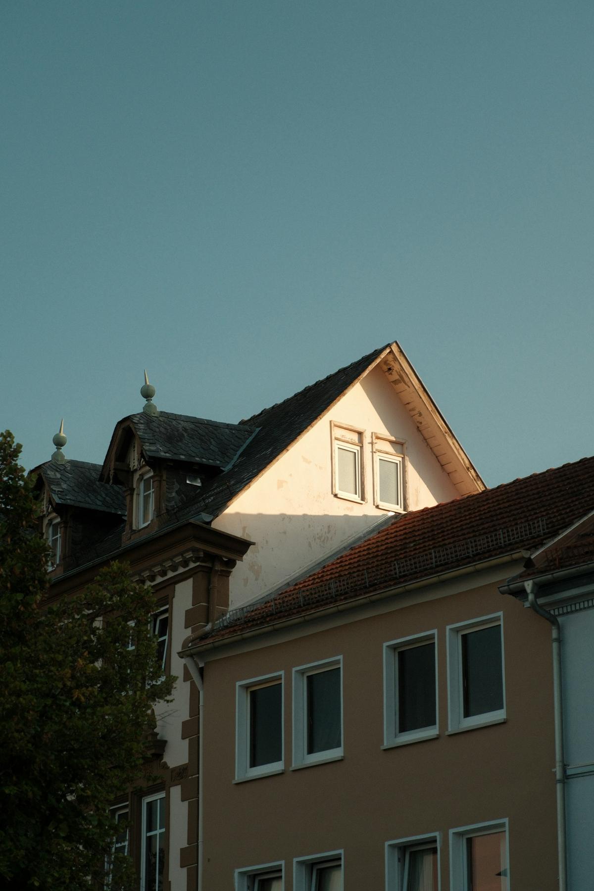 Giebel und Gauben eines Altbaus vor blauem Himmel